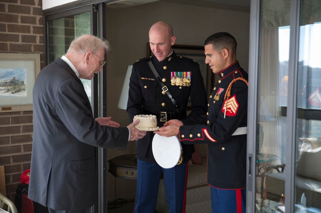 Maj. Paul Steketee and Sgt. Jason Pena deliver a birthday cake to Gen. P.X. Kelly (Ret.), the 28th Commandant of the Marine Corps, at his home in Arlington, Va., on Nov. 10, 2014. Living commandants in the National Capital Region are delivered a birthday cake every year on the Marine Corps' birthday. (U.S. Marine Corps photo by Lance Cpl. Christian Varney