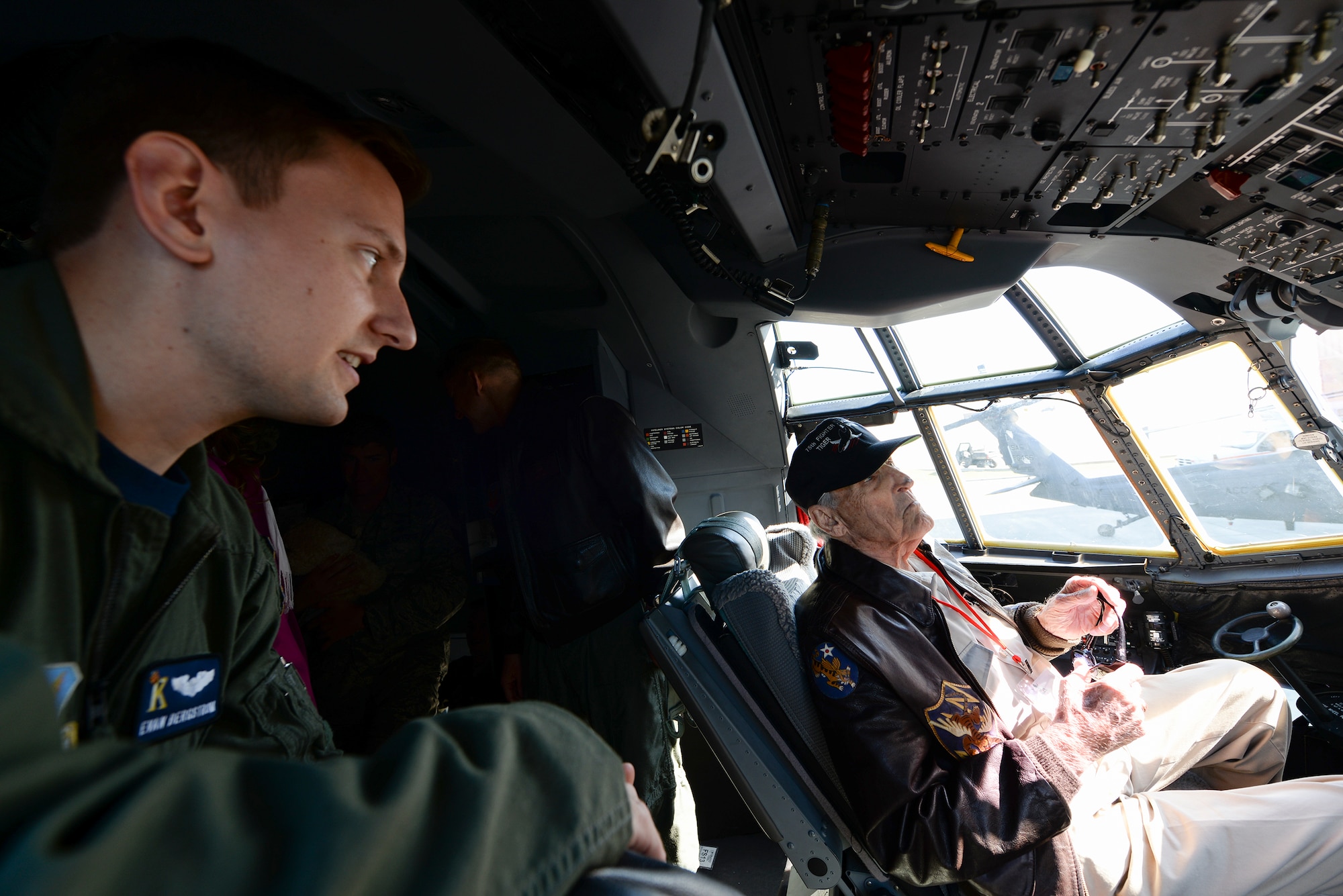 Capt. Evan Bergstrom talks about the upgraded controls in the aircraft with J.M. Taylor during the 2014 Flying Tiger Reunion heritage day, Nov. 14, 2014, at Moody Air Force Base, Ga. Taylor is a former 75th Fighter Squadron pilot and World War II veteran who spent 10 months as a prisoner of war, including two months in solitary confinement. Bergstrom is a 71st Rescue Squadron HC-130J Combat King II pilot. (U.S. Air Force photo/Master Sgt. Sonny Cohrs) 