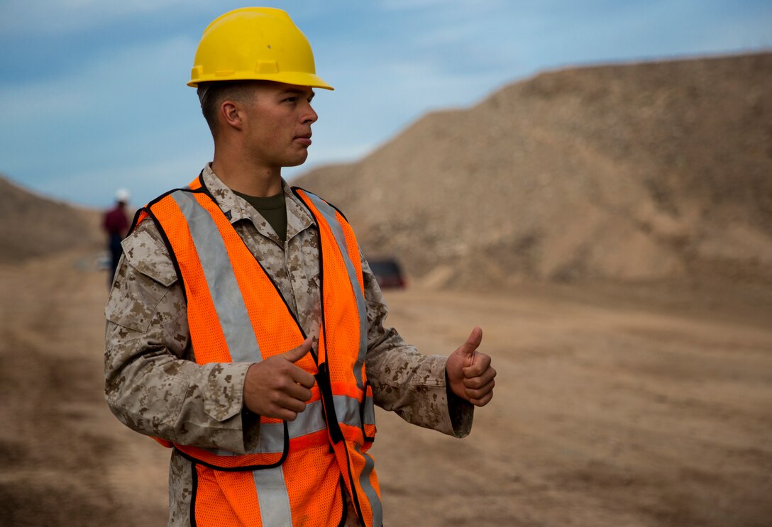 Cpl. Austin Smith, a heavy equipment operator with Marine Wing Support Squadron 371, guides the tractor as it levels the ground at the construction site in El Centro, Calif., Feb. 25. The joint units of MWSS-371, based in Marine Corps Air Station Yuma, Ariz., and 7th Engineer Support Battalion, based in Marine Corps Base Camp Pendleton, Calif., worked together to enhance the homeland security of the nation.    