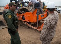 Louis Garcia, an El Centro Border Patrol agent, discusses the project with 1st Lt. Austin Brown, the mission commander for the West Desert El Centro All Weather Road Improvements, at the U.S./Mexico Border in El Centro, Calif., Feb. 25. 