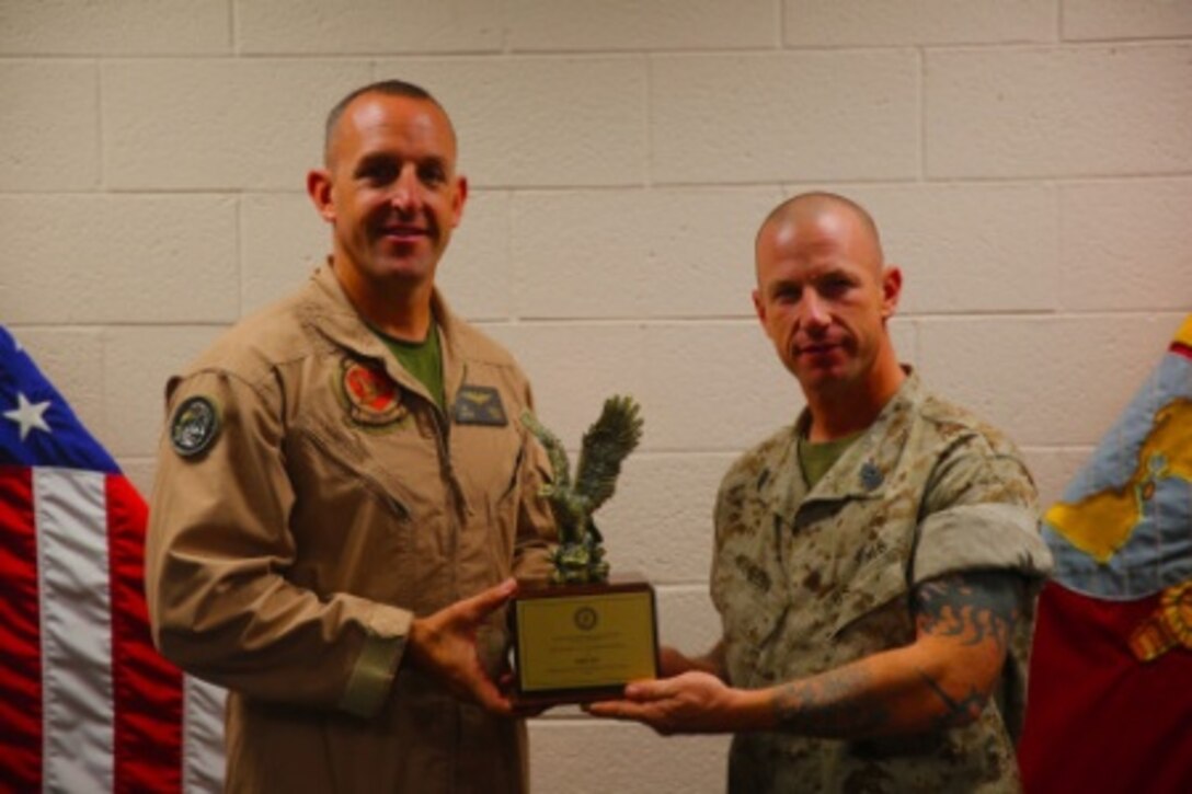 Lt. Col. Toby Moore (left), the Commanding Officer of Marine Attack Squadron 311, hold the Lawson H.M. Sanderson Award, which is awarded to the Marine Attack Squadron of the Year. VMA-311 deployed to Camp Bastion, Afghanistan and provided uninterrupted aviation support during 2013. The squadron also deployed a detachment of Marines to the 15th Marine Expeditionary Unit.


