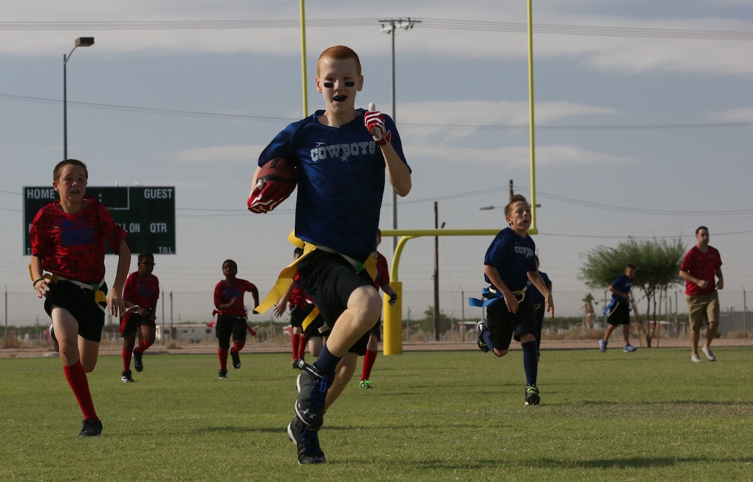 The Cowboys take the ball into the end zone against Team USA as part of a flag football game hosted by Marine Corps Community Services Youth Sports Program Saturday, Sept. 27, 2014, on Marine Corps Air Station Yuma, Ariz.  The MCCS Youth Sports Program allows children ages five through twelve to participate in the flag football teams.