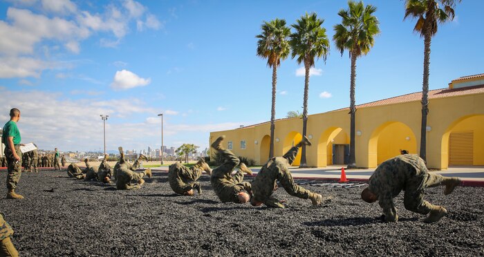 Recruits of Mike Company, 3rd Recruit Training Battalion, perform a shoulder roll during the Marine Corps Martial Arts Program test aboard Marine Corps Recruit Depot San Diego, Nov. 12.  Recruits were required to show confidence and no hesitation in the execution of a technique or the instructor would make them try again individually.  If unsuccessful, he would receive an “X” on his score card, indicating he failed the technique.