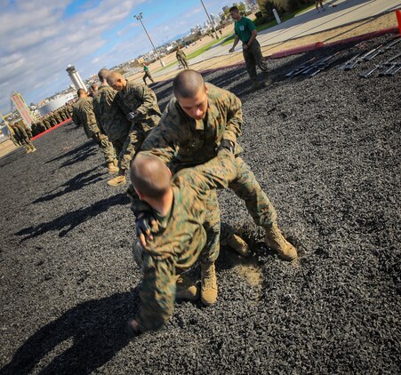 Recruits of Mike Company, 3rd Recruit Training Battalion, perform a leg sweep during the Marine Corps Martial Arts Program test aboard Marine Corps Recruit Depot San Diego, Nov. 12.  After successfully completing the test, recruits earned the first belt level of MCMAP; the tan belt.