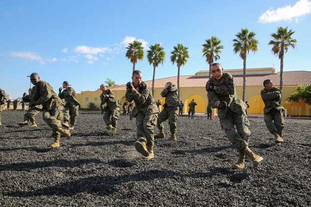 Recruits of Mike Company, 3rd Recruit Training Battalion, execute a right side break fall during the Marine Corps Martial Arts Program test aboard Marine Corps Recruit Depot San Diego, Nov. 12.  After successfully completing the test, recruits earned the first belt level of MCMAP; the tan belt.