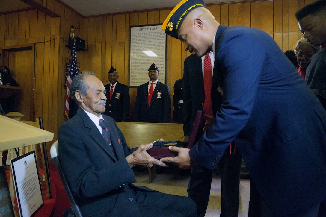 Ronald C. Johnson (right), a retired master gunnery sergeant and the Montford Point Marines Deputy Director, presents William J. Brashear (left), a Montford Point Marine, with the Congressional Gold Medal at Mount Era Baptist Church in Morgan City, La., Nov. 15, 2014. The Congressional Gold Medal is the nation’s highest civilian honor given by Congress for distinguished achievement. On Nov. 23, 2011, President Barrack Obama signed into legislation a law that awarded the Congressional Gold Medal to all Montford Point Marines, the first African-Americans allowed to enlist in the Marine Corps. 