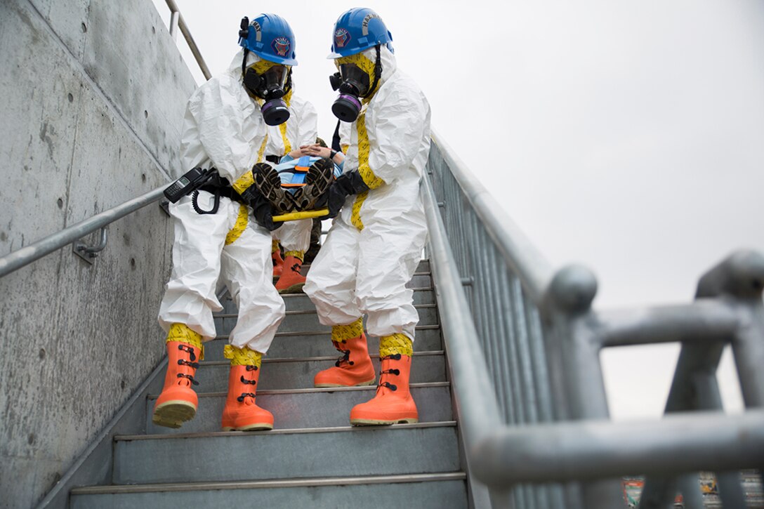 Fire fighters with the Marine Corps Air Station Iwakuni Fire Station extract a victim from the fire training tower during Chemical Biological Radiological Nuclear and Hazardous Material Emergency Response Operations aboard MCAS Iwakuni, Japan, Nov. 8, 2014. This was the first time the MCAS Iwakuni Fire Station, Marine Aircraft Group 12 and the Japan Ground Self-Defense Force’s 102nd Central Nuclear Biological Chemical Weapon Defense Unit collaborated to conduct this type of training.