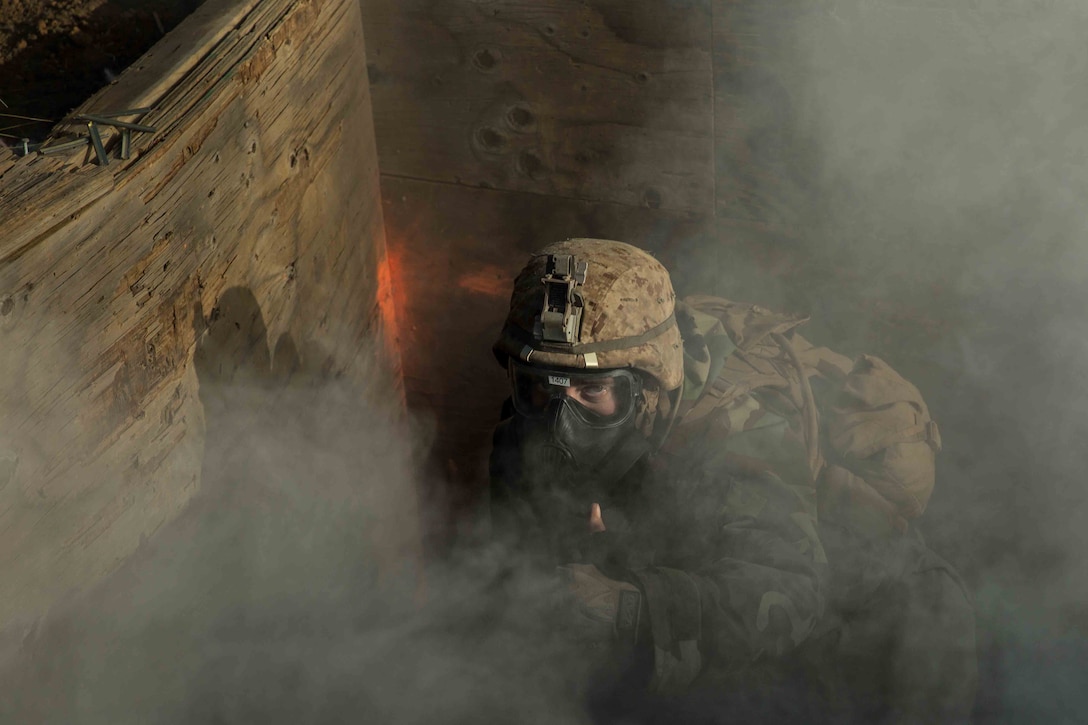 A Marine with Fox Company, 2nd Battalion, 3rd Marine Regiment, puts his thumb up after he successfully donned and cleared his M50 Gas Mask during a simulated counterattack on Range 10, Nov. 8, 2014. 