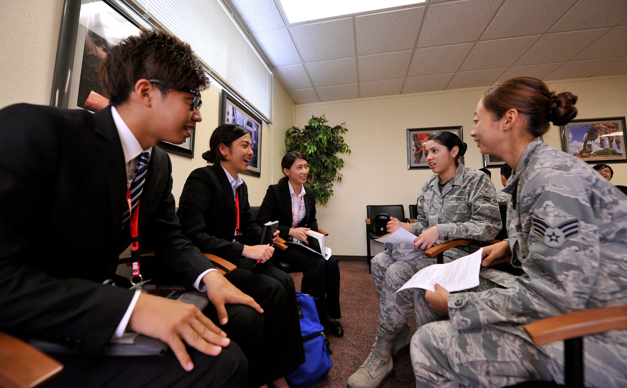 U.S. Air Force Senior Airman Soohwa One, 18th Dental Squadron dental assistant, and Airman 1st Class Vivian Chagollan, 18th DS dental lab technician, talk with students from the Nikkei College of Business in Okinawa City at an English conversation class during their base facility tour on Kadena Air Base, Japan, Nov. 14, 2014. During their tour, the students shared the history and culture of Okinawa with the Airmen. (U.S. Air Force photo/Naoto Anazawa)