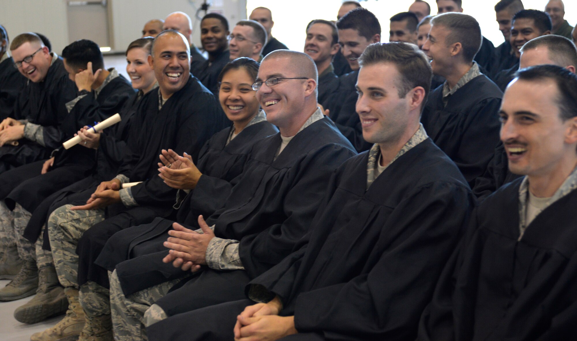 Graduates laugh and celebrate during Creech Air Force Base’s first-ever Community College of the Air Force graduation, which took place on base Nov. 14, 2014. The CCAF is a large community college offering 2,000 courses and having more than 250,000 students. (U.S. Air Force photo by Staff Sgt. Adawn Kelsey)