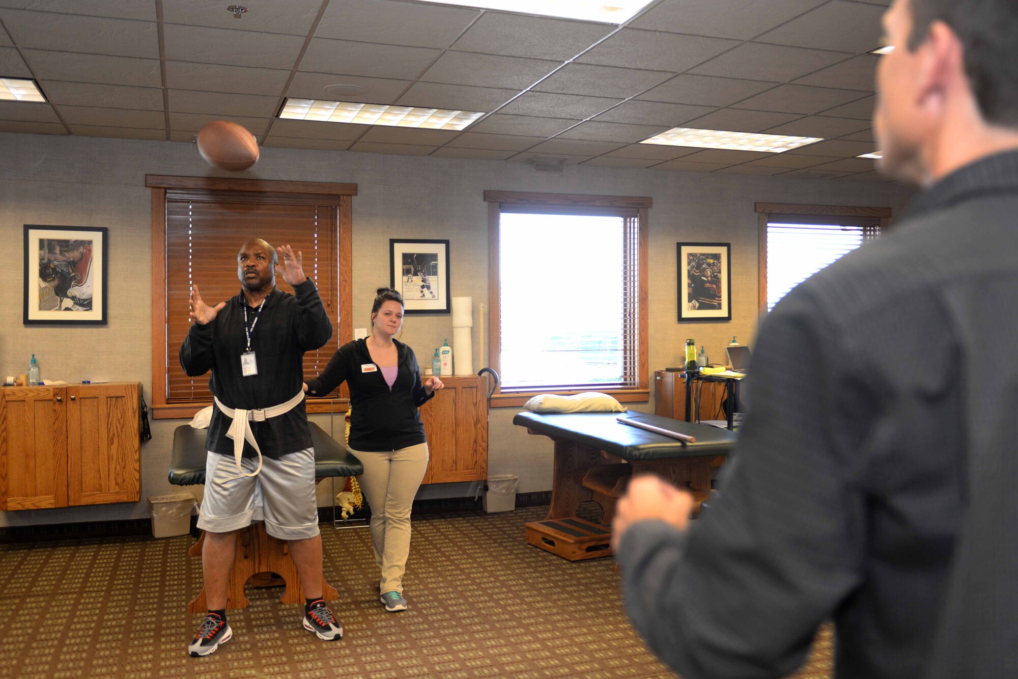 Donald Bell, 28th Bomb Wing equal opportunity director, catches a football during a physical therapy session in Rapid City, S.D., Oct. 8, 2014. During Physical therapy, Bell goes through exercises which force him to use both hands and legs, in an effort to recover the movement on his left side. (U.S. Air Force photo by Airman 1st Class Rebecca Imwalle/Released)
