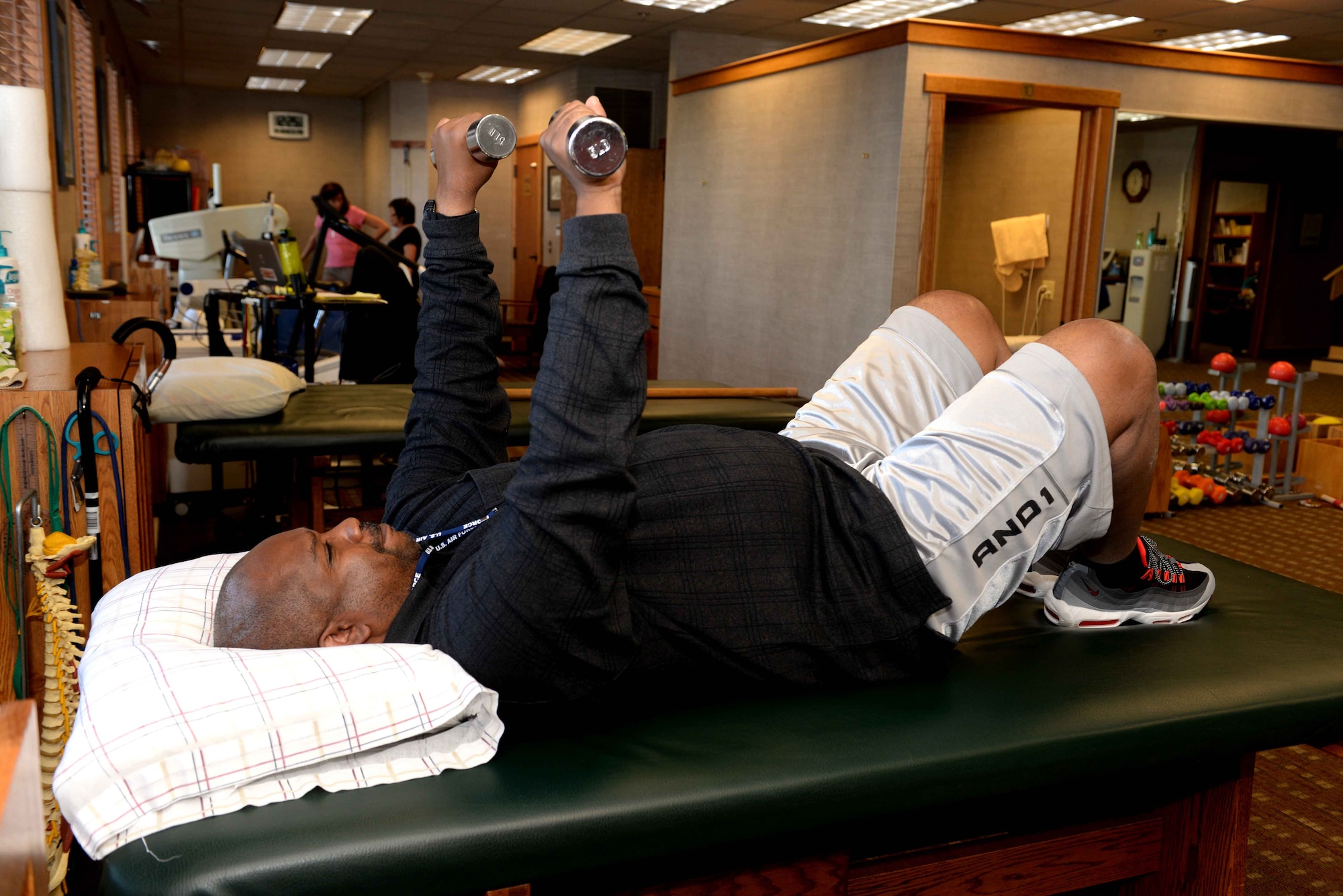 Donald Bell, 28th Bomb Wing equal opportunity director, lifts weight during a physical therapy session in Rapid City, S.D., Oct. 8, 2014. Bell is attending physical therapy due to recover movement in his left arm and leg that became paralyzed due to nerve damage in April. (U.S. Air Force photo by Airman 1st Class Rebecca Imwalle/Released)