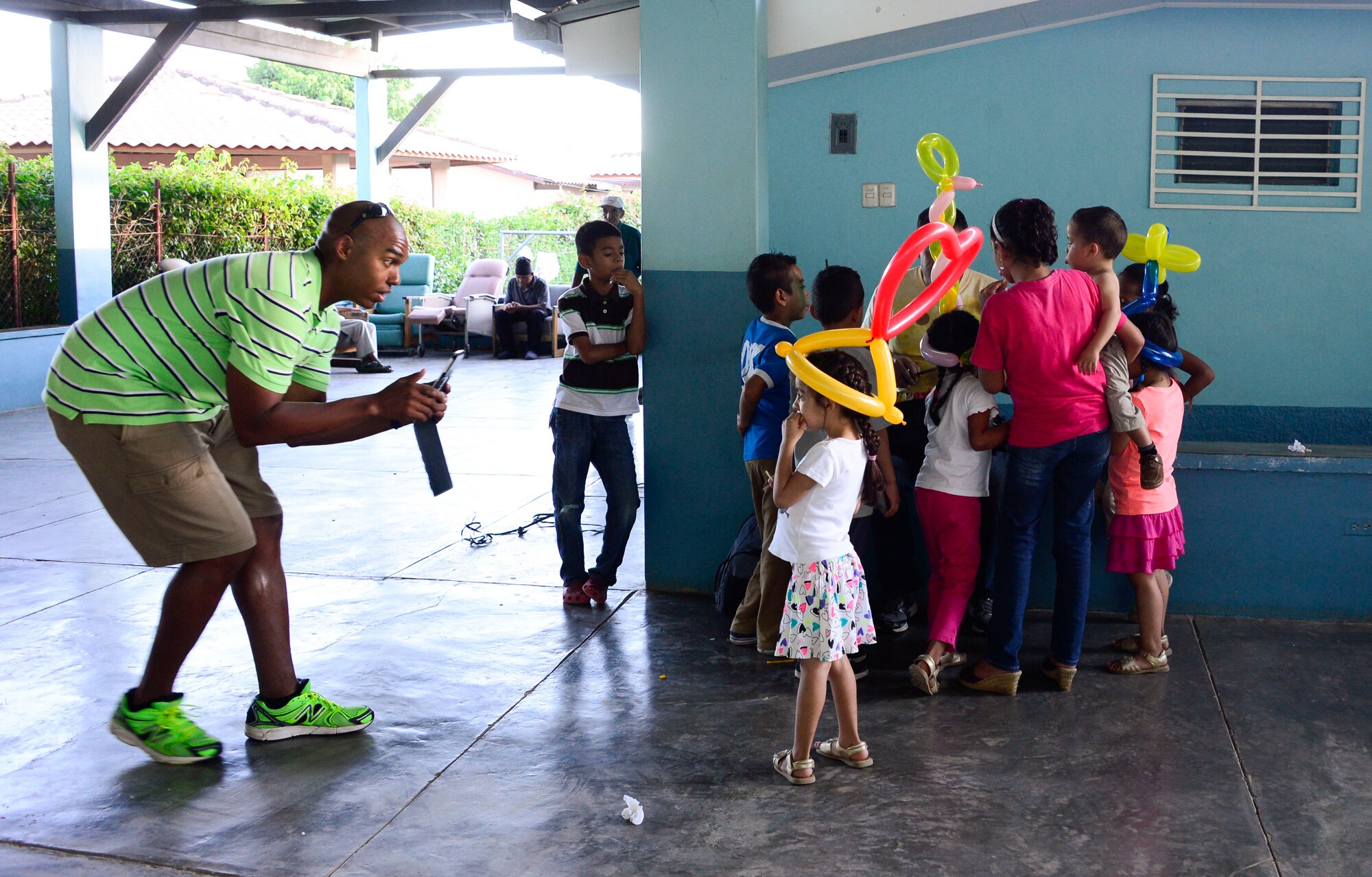 U.S. Army Maj. Darwin Maull, Joint Task Force-Bravo operations strategist, takes pictures of a young girl with a balloon hat during a visit to the Sisters of Charity Orphanage in Comayagua, Honduras, Nov. 16, 2014.  The Sisters of Charity Orphanage is one of seven different orphanages from around the Comayagua Valley that the U.S. military personnel assigned to JTF-Bravo have supported over the past 17 years. In addition to spending time with interacting with children, members have also collected and donated much-needed supplies and food, as well as helped in minor construction work on the buildings in which the children live. (U.S. Air Force photo/Tech. Sgt. Heather Redman)
