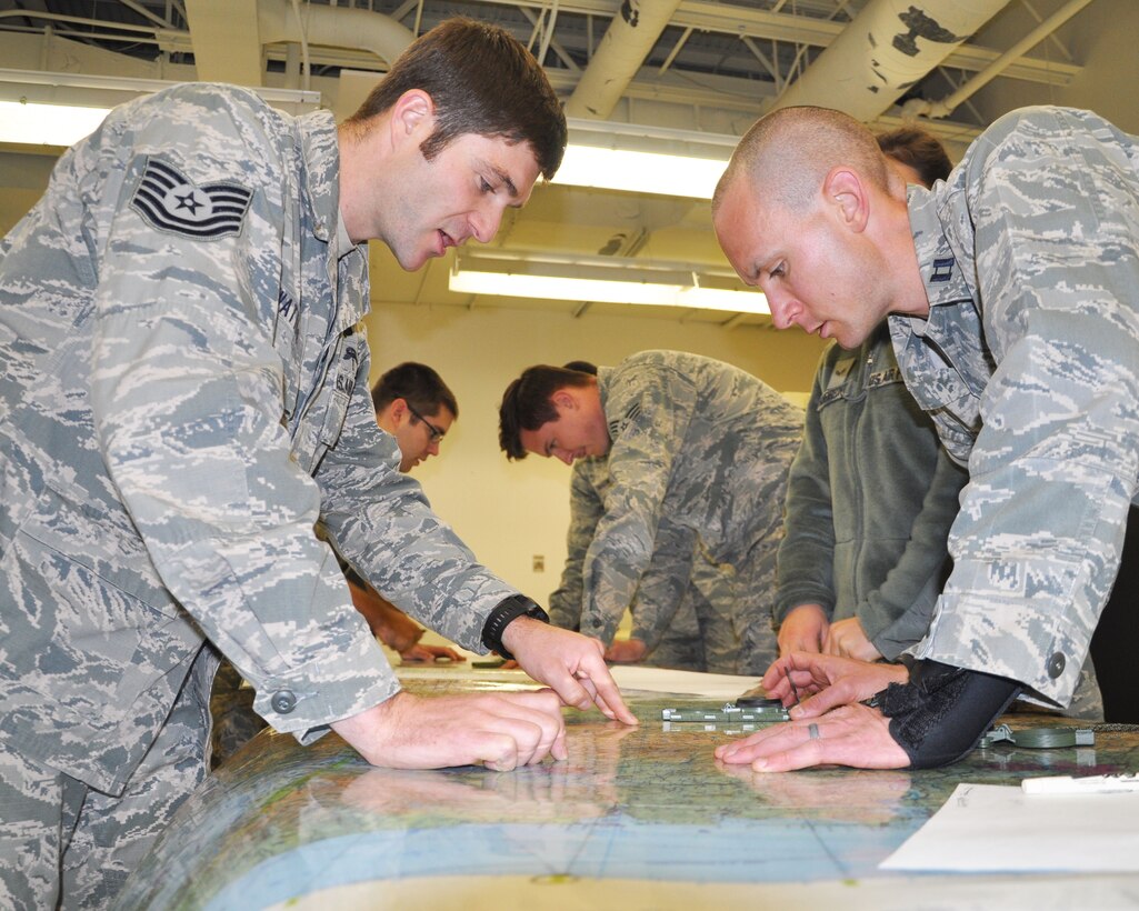 Tech. Sgt. Justin Watters, 22nd Operations Support Squadron survival, evasion, resistance and escape specialist, instructs Capt. Zachary Anderson, 931st Air Refueling Group Public Affairs Officer, during a basic land navigation training course Nov. 17, 2014, McConnell Air Force Base.  In addition to land navigation training, Watters teaches ground and water survival training, a week-long Army combatives course, personnel recovery operation support training and environmental threat analysis for different units on base. (U.S. Air Force photo by Staff Sgt. Abigail Klein)