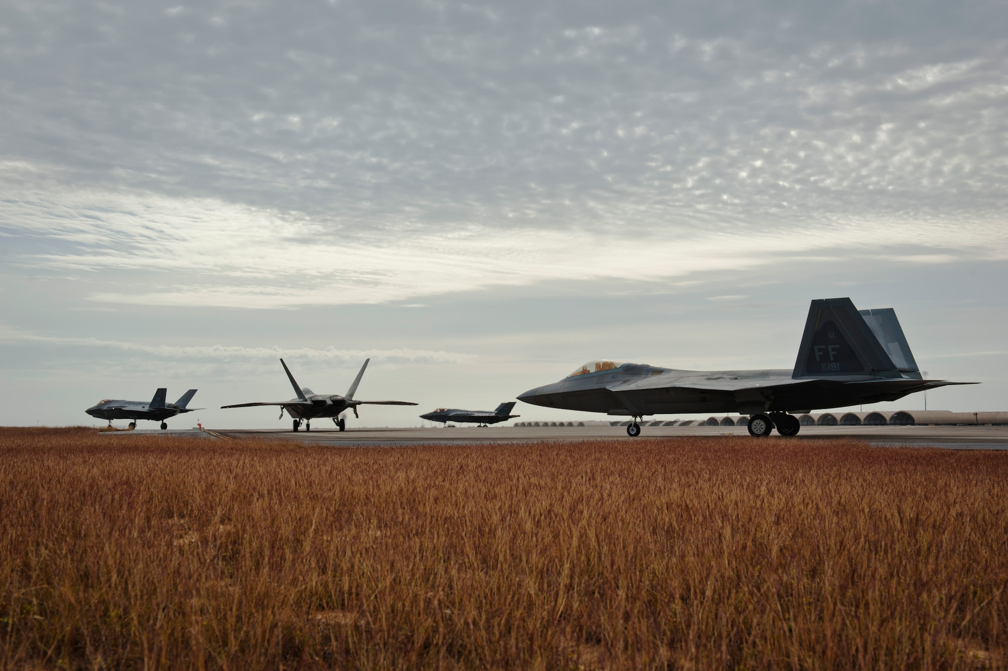 F-22 Raptors from the 94th Fighter Squadron, Joint Base Langley-Eustis, Virginia, and F-35A Lightning IIs from the 58th Fighter Squadron, Eglin Air Force Base, Florida, perform final preflight checks before taking off for an integration training mission on Eglin Training Range, Florida, Nov. 6, 2014. The F-35s and F-22s flew offensive counter air, defensive counter air and interdiction missions, maximizing effects by employing fifth-generation capabilities together. (U.S. Air Force photo/Staff Sgt. Marleah Robertson)