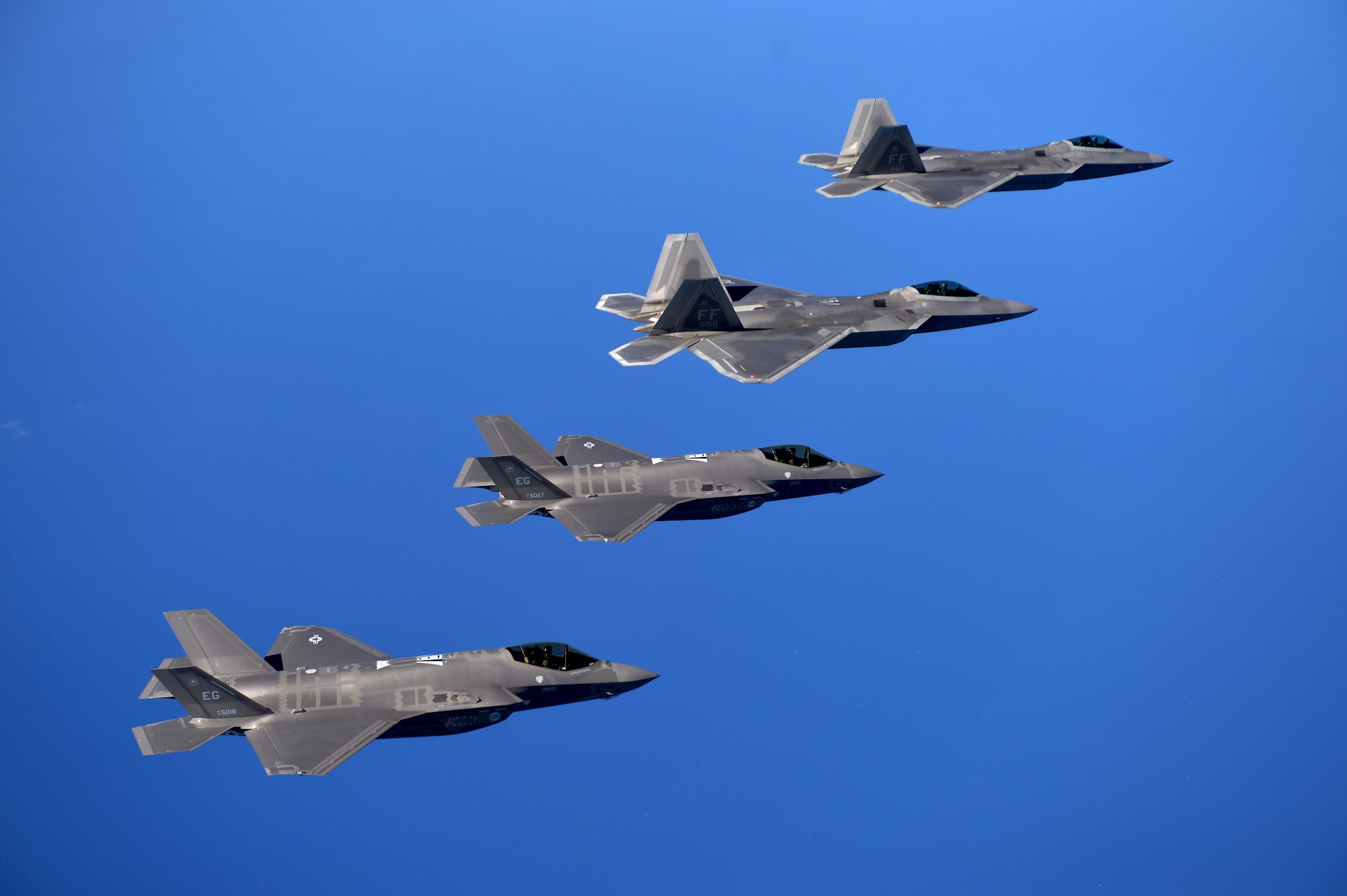 F-22 Raptors from the 94th Fighter Squadron, Joint Base Langley-Eustis, Virginia, and F-35A Lightning IIs from the 58th Fighter Squadron, Eglin Air Force Base, Florida, fly in formation after completing an integration training mission over the Eglin Training Range, Florida, Nov. 5, 2014. The purpose of the training was to improve integrated employment of fifth-generation assets and tactics. The F-35s and F-22s flew offensive counter air, defensive counter air and interdiction missions, maximizing effects by employing fifth-generation capabilities together. (U.S. Air Force photo/Master Sgt. Shane A. Cuomo)