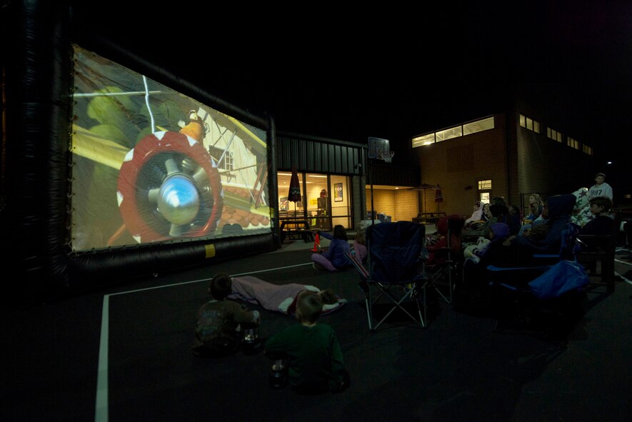 Children and staff from Moody’s youth programs watch a movie during a campout Nov. 15, 2014, at Moody Air Force Base, Ga.  In addition to a movie, children from the youth programs made hotdogs and s’mores, played games and completed a scavenger hunt. (U.S. Air Force photo by Airman 1st Class Dillian Bamman/Released)