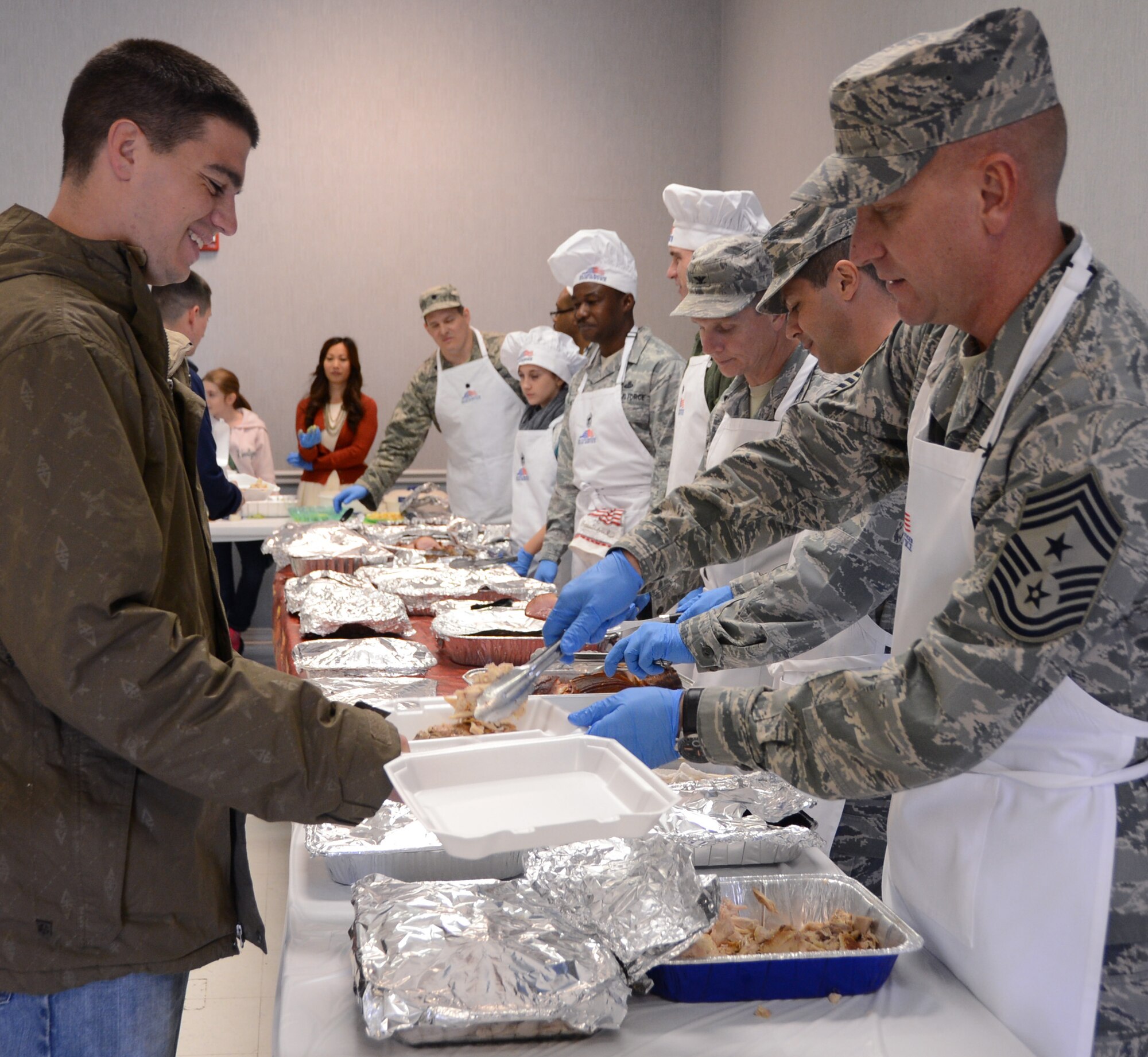 Airmen are served turkey and ham by base leadership during a Thanksgiving luncheon for dorm Airmen on Barksdale Air Force Base, La., Nov. 28, 2013. The meal was held for more than 100 dorm Airmen unable to go home for Thanksgiving and Airmen who were on duty during the holiday. The First Sergeant’s Council held the luncheon for the Airman, and base leadership and volunteers prepared and served the food.  (U.S. Air Force photo/Staff Sgt. Amber Corcoran)