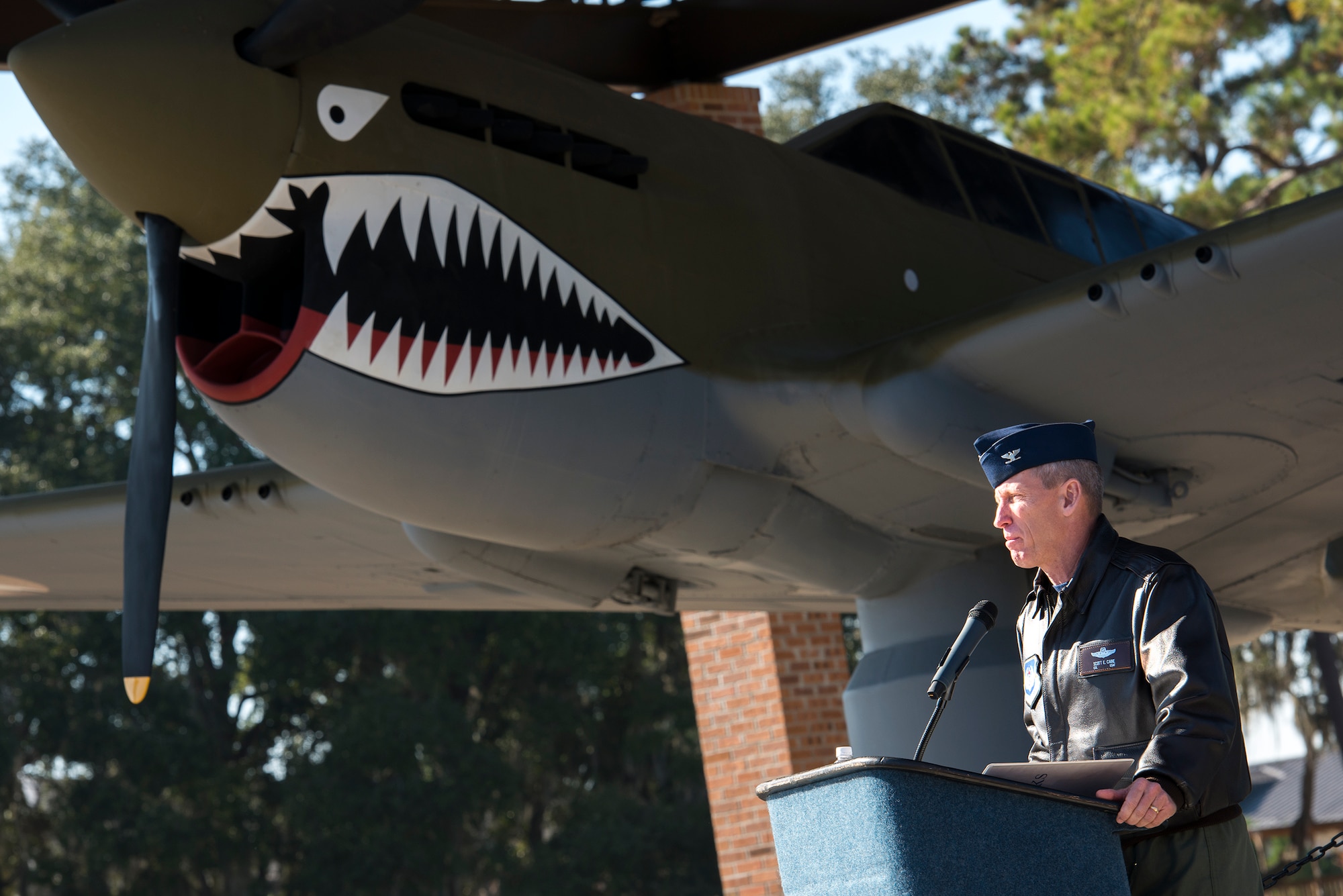 U.S. Air Force Col. Scott Cane, Ninth Air Force vice commander, speaks during the P-40 Warhawk pavilion dedication ceremony as part of the Flying Tiger Reunion Nov. 14, 2014, at Moody Air Force Base, Ga. Cane spoke about his personal experience flying with  Lt. Col Robert “Muck” Brown and the far-reaching legacy he left behind. (U.S. Air Force photo by Airman 1st Class Ryan Callaghan/Released)