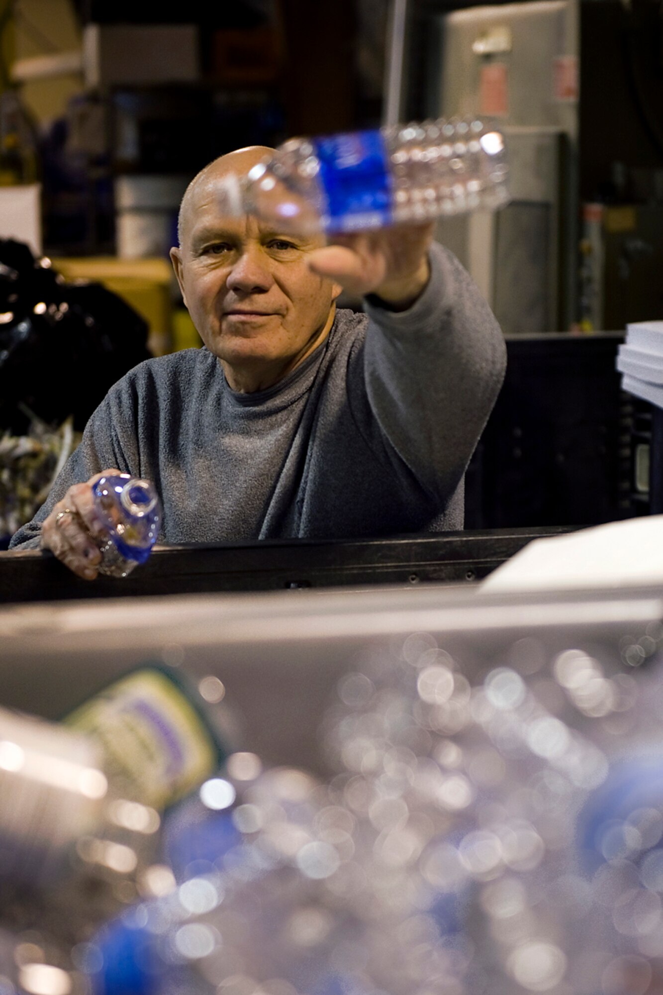 Dan Miller, 434th Civil Engineer Squadron general services and support worker, tosses a plastic water bottle as he sorts through recycling at the CE complex at Grissom Air Reserve Base, Ind., Oct. 30, 2014. Last year alone, Grissom recycled 420 tons of material as part of its recycling program.  (U.S. Air Force photo/Mark R. W. Orders-Woempner)