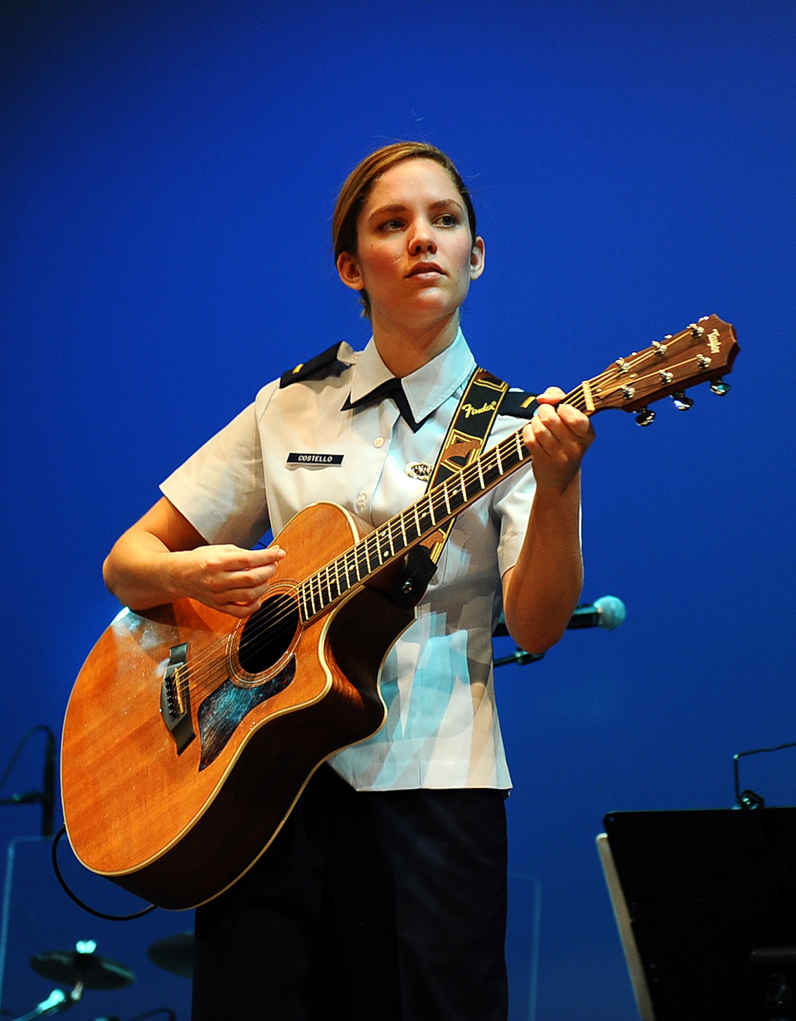 U.S. Air Force 2nd Lt. Carly Costello, 55th Wing Public Affairs Officer, plays guitar with the U.S. Air Force’s Heartland of America Band at Blair High School on Nov. 8, 2014.  The Salute to Veterans concert Series was a five-day venture with thousands of attendees.  (U.S. Air Force photo by Josh Plueger/Released)