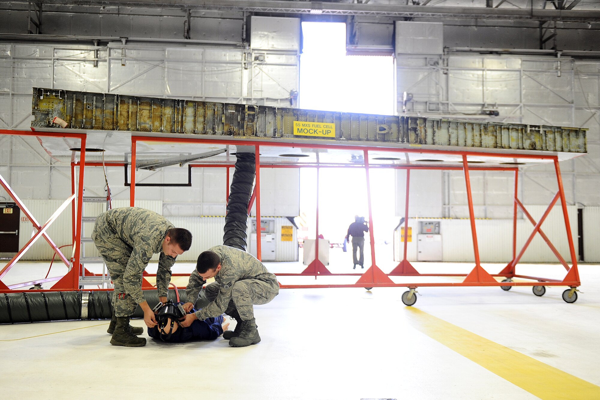 U.S. Air Force Senior Airmen Mathew Wambles (left) along with his colleague Kyle Quiggle, successfully rescue a dummy from a fuel cell during training on Nov. 10 at Offutt Air Force Base, Neb.  Fuel systems repairmen and firefighters must be knowledgeable on the retrieval of crew that may have lost consciousness while performing repairs in the fuel cell.  (U.S. Air Force photo by Josh Plueger/Released)