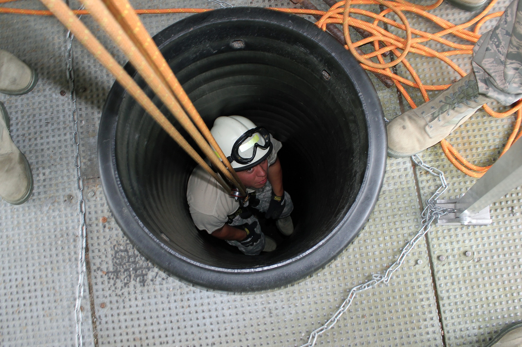 Staff Sgt. Nate Grys is lowered into a large pipe during a confined space exercise conducted by the firefighters of the 179th Airlift Wing, Ohio Air National Guard, during a training deployment to the Alpena Combat Readiness Training Center, Mich., Aug. 20, 2014. The firefighters spent a week at Alpena, training on live-fire exercises involving a simulated structure fire and aircraft fire, and on various rescue scenarios. (U.S. Air National Guard photo by Tech. Sgt. Dan Heaton)