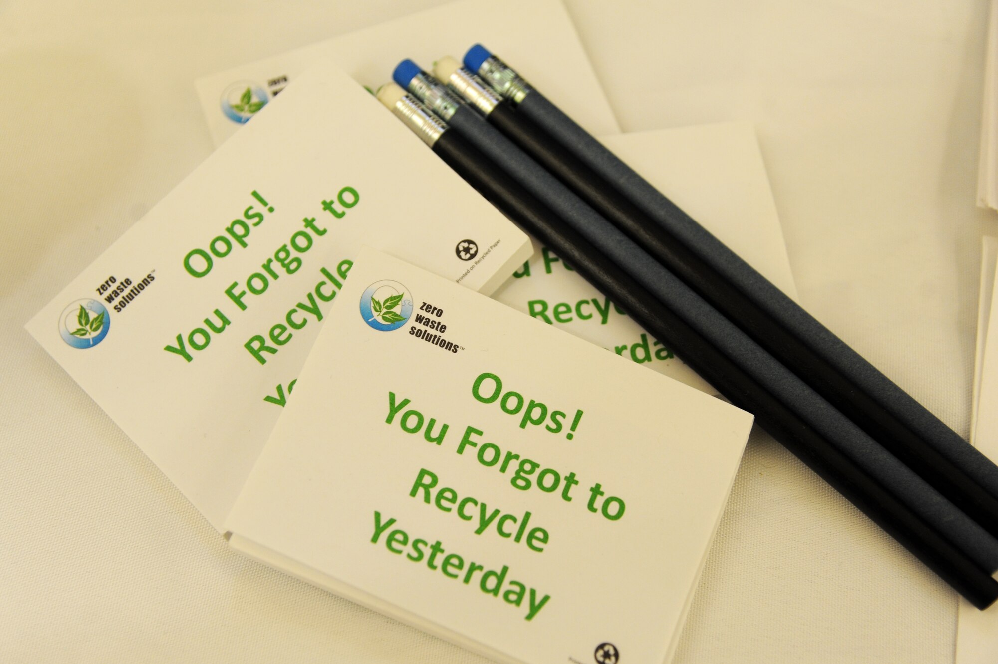Recycled materials provided by Zero Waste Solutions, including post-its and pencils made from tires and blue jeans, sit on display at an American Recycling Day booth Nov. 14, 2014, in the base exchange, Keesler Air Force Base, Miss. The base environmental office and the recycling center worked together to provide pertinent information to shoppers. (U.S. Air Force photo by Kemberly Groue)