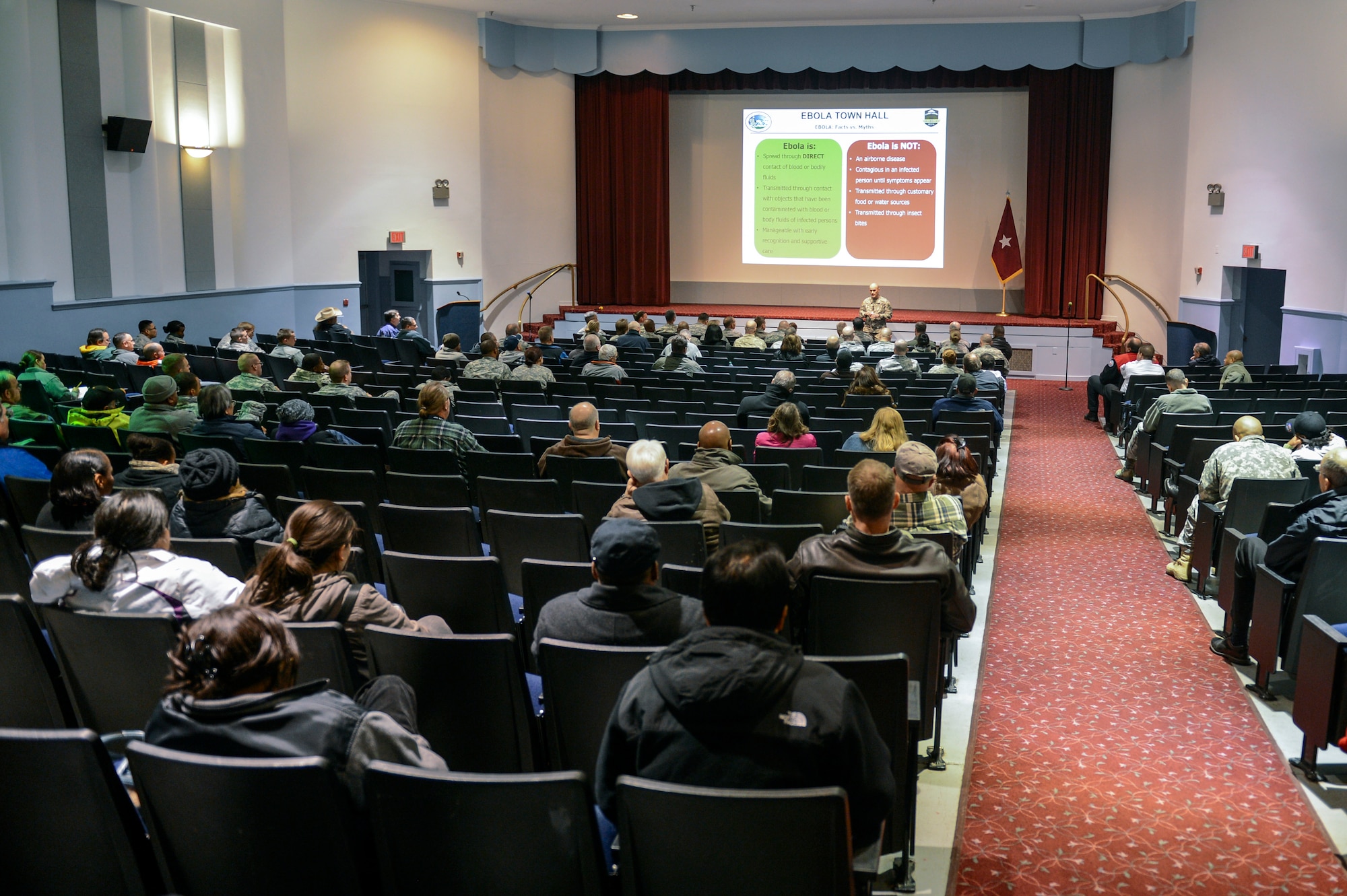 Airmen and civilians listen to Lt. Col. Rodd Marcum, Madigan Preventative Medicine physician, at the McChord Field Theater, Joint Base Lewis-McChord, Wash., Nov. 13, 2014, during the JBLM Town Hall Ebola update. The purpose of the Town Hall was to address concerns after JBLM was recognized for sending troops into West Africa in support of Operation United Assistance. (U.S. Air Force photo/Staff Sgt. Russ Jackson)