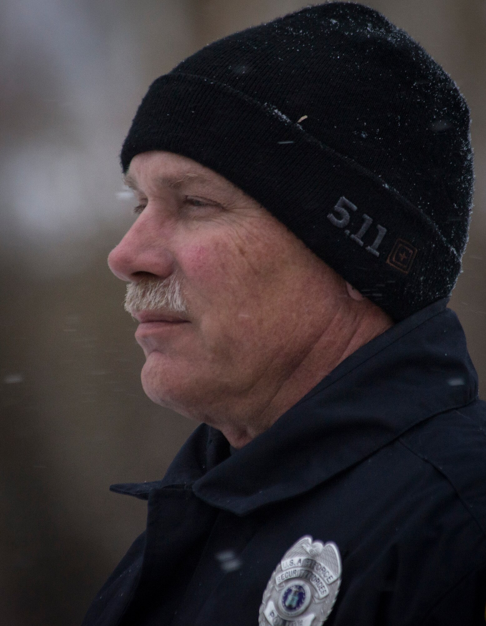 Officer Robert Hendrick, Department of the Air Force police officer, waits for retreat to take down the flag for the evening at Mountain Home Air Force Base, Idaho, Nov. 13, 2014. The flag is taken down every day at 5 p.m. to signify the end of the duty day. (U.S. Air Force photo by Airman 1st Class Jessica H. Smith/RELEASED)