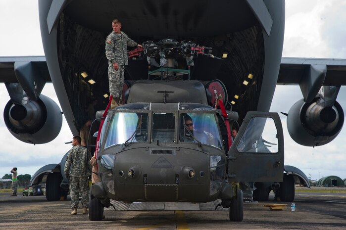 Service members unload a U.S. Army UH-60 Black Hawk from a U.S. Air Force C-17 Globemaster III Oct. 30, 2014, during Operation United Assistance. The U.S. Africa Command-led operation provides command and control, logistics, training and engineering support to the U.S. government’s efforts to contain the Ebola virus outbreak in West African nations. (U.S. Air Force photo/Staff Sgt. Gustavo Gonzalez)