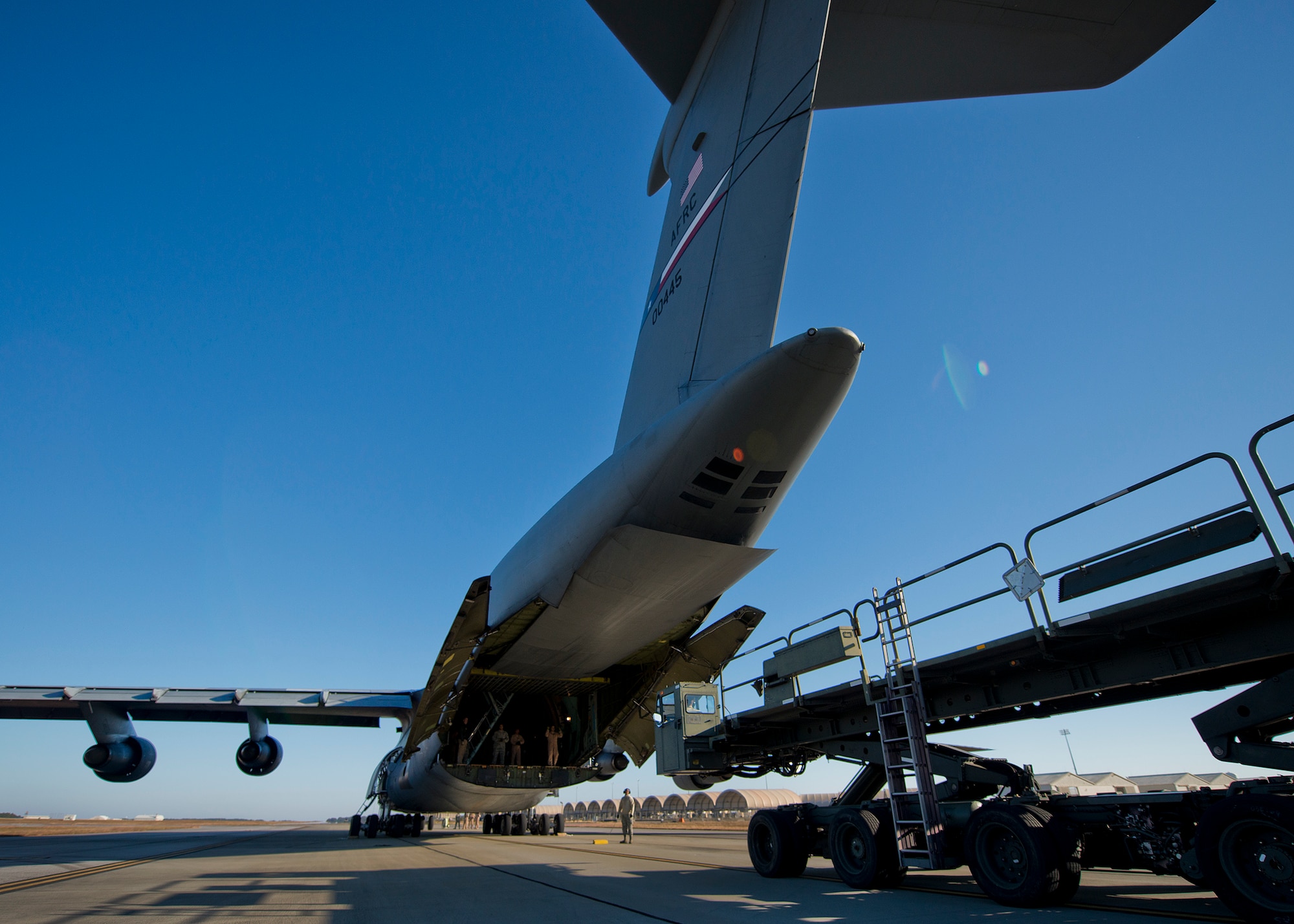 A 96th Test Wing pallet carrier moves into place behind a 433rd Airlift Wing C-5 Galaxy to offload cargo at Eglin Air Force Base, Fla., Nov. 14.  The 96th Logistics Readiness Squadron’s air terminal operations Port Dawgs unloaded approximately eight Army pallets from the C-5. The section moves an average of 160 tons of cargo and 570+ passengers per month.  (U.S. Air Force photo/Samuel King Jr.)