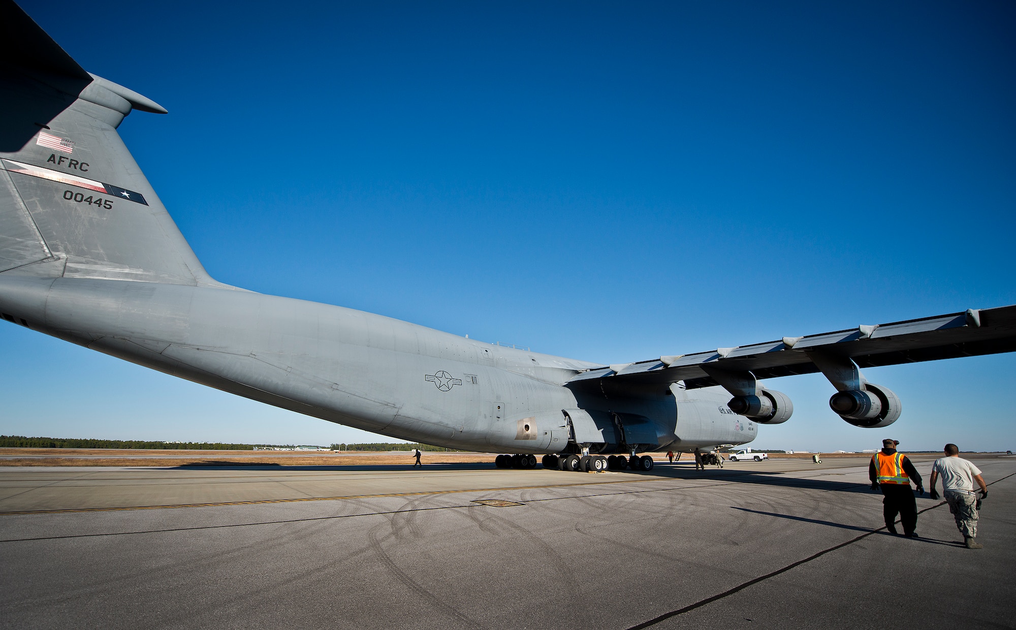 An 96th Test Wing ground crew member and a 96th Logistics Readiness Squadron port dawg move to the front of the C-5 Galaxy upon its arrival at Eglin Air Force Base, Fla., Nov. 14.  The squadron’s Port Dawgs unloaded approximately eight Army pallets from the C-5. The section moves an average of 160 tons of cargo and 570+ passengers per month.  (U.S. Air Force photo/Samuel King Jr.)