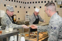 910th Airlift Wing Command Chief Master Sgt. Steven Larwood serves the holiday meal to the wing’s Airmen at the Community Activity Center here, Nov. 1, 2014. Chief Master Sgt. David Kane, 757th Airlift Squadron Chief Flight Engineer, assists in the background. Wing leadership serving the holiday meal to the 910th’s Citizen Airmen is a long-standing tradition at YARS. (U.S. Air Force photo/Tech. Sgt. Rick Lisum)