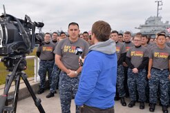 Lt. Benjamin Cavin, Naval Nuclear Power Training Command public affairs officer, is interviewed Nov. 14, 2014, by Mike Kocis, a WCBD-TV cameraman, at Patriot’s Point in Mt. Pleasant, S.C. Hundreds of Joint Base Charleston Sailors and Airmen were participating in the United Way Day of Caring, which provides an opportunity for volunteer teams to partner with local agencies and schools to increase community engagement. NNPTC Sailors were at Patriot’s Point cleaning spaces onboard the aircraft carrier as well as painting, making sand bags for exhibits and cleaning the grounds. (U.S. Air Force photo/Eric Sesit)