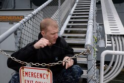 Petty Officer Third Class Jake Hoskins, a Naval Nuclear Power Training Command student, rigs a safety net Nov. 14, 2014, on one of the USS Yorktown’s brows at Patriot’s Point in Mt. Pleasant, S.C.  Hundreds of Joint Base Charleston Sailors and Airmen participated in the United Way Day of Caring, which provides an opportunity for volunteer teams to partner with local agencies and schools to increase community engagement. NNPTC Sailors were at Patriot’s Point cleaning spaces onboard the aircraft carrier as well as painting, making sand bags for exhibits and cleaning the grounds. (U.S. Air Force photo/Eric Sesit)