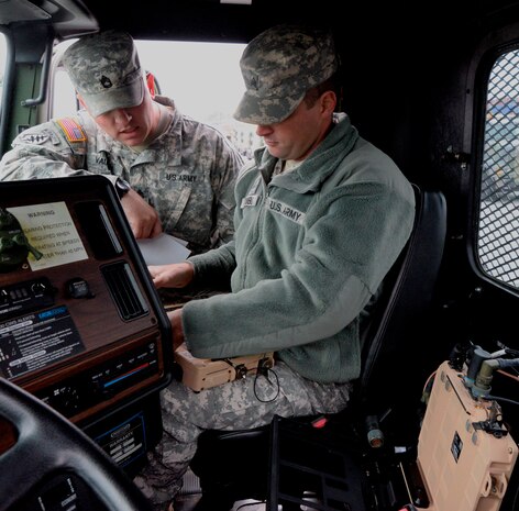 Sgt. 1st Class Jack Vaughn (left), and Sgt. Jonathan Trimble, from the 941st Transportation Company, prepare to mount a Movement Tracking System onboard a M 915 A3 truck, Nov. 14, 2014, at the Army Reserve Center on Joint Base Charleston, S.C. Vaughn and Trimble were preparing the trucks for a convoy to Ft. Jackson, S.C. for the Reserve unit’s yearly weapons training qualification. (U.S. Air Force photo/Eric Sesit)
