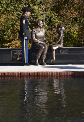 First Sergeant Rebecca Edwards, with the Oklahoma Army National Guard, admires the statue which was made in her honor during the Women’s Veterans Monument unveiling at Patriot Park in Del City Tuesday. The monument features five women, representing each military branch, holding hands to show sisterhood. Committee members wanted to not only depict women in the five main military branches, but also Citizen-Soldiers in the National Guard. The monument also includes names and dates of service of the Del City military members who died in foreign wars. (Air Force photo by Kelly White)