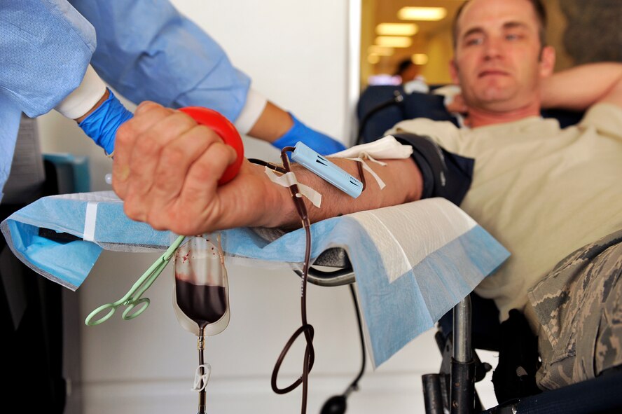 U.S Air Force Master Sgt. Matthew Conlon, 18th Maintenance Group resource advisor, squeezes his hand to increase the blood flow through his veins during a blood drive at the Exchange on Kadena Air Base, Japan, Nov. 13, 2014. The blood drive kicked off Blood Donor Month for the Armed Services Blood Program. The blood is distributed for use in Korea, the Middle East, and locally to support the armed forces personnel. (U.S. Air Force photo by Naoto Anazawa/Released)