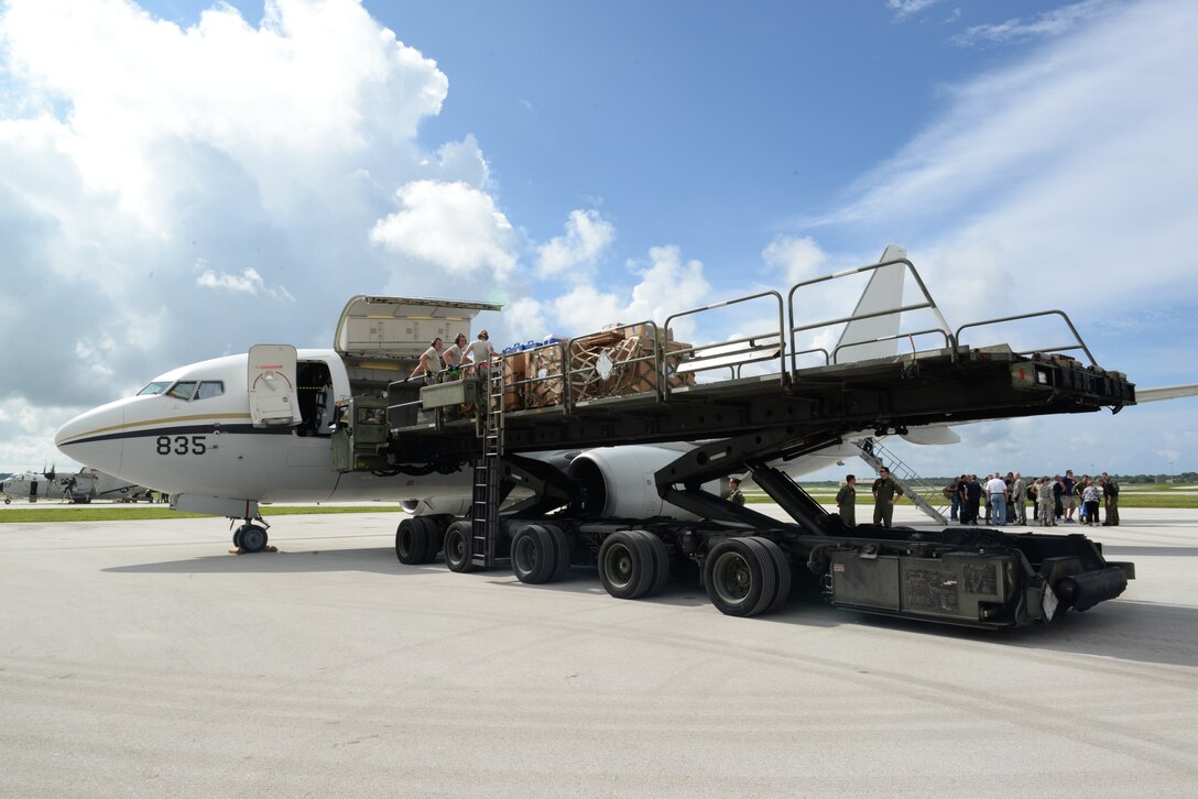 Airmen from the 734th Air Mobility Squadron offload cargo using a Halvorsen 25K Loader while 36th Logistics Readiness Squadron Airmen greet the Cooks from the Valley Nov. 4, 2014, on Andersen Air Force Base, Guam. The cooks were on their way to the U.S.S. George Washington, but were rerouted to Andersen due to weather. (U.S. Air Force photo by Airman 1st Class Amanda Morris/Released)