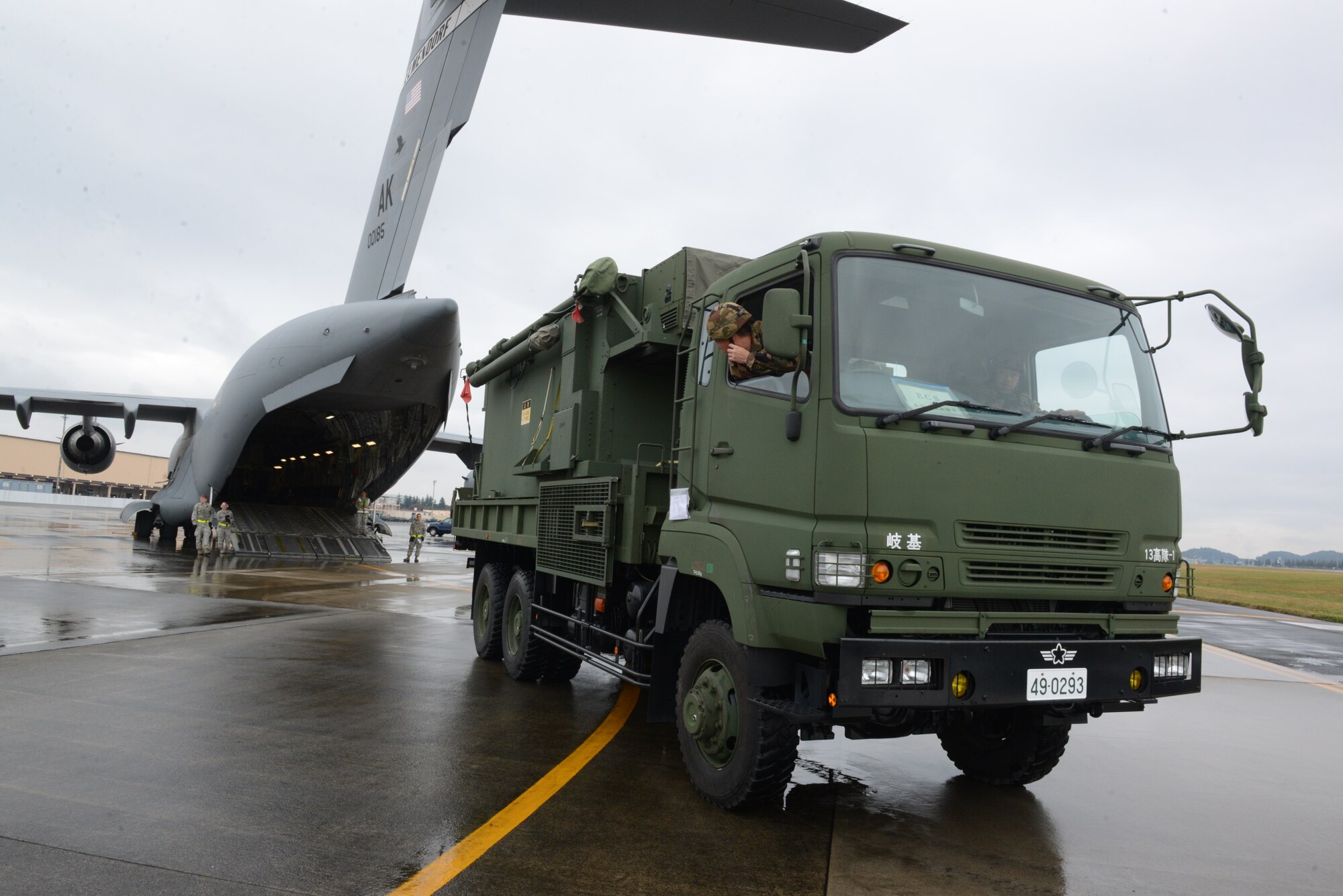 A Japan Air Self-Defense member prepares to back an engagement command station vehicle into a C-17 Globemaster III at Yokota Air Base, Japan, Nov. 06, 2014.Two engagement command station vehicles were loaded onto the C-17 as part of Keen Sword 2015, a bilateral exercise which strengthens Japan and United States military interoperability. (U.S. Air Force photo by Tech. Sgt. Melissa K. Mekpongsatorn/Released)