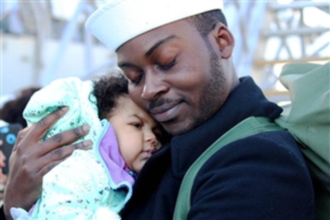 Navy Petty Officer 3rd Class Carter Davonte holds his daughter for the first time in Norfolk, Va., Nov. 15, 2014. The child was born while Davonte was deployed aboard the guided-missile destroyer USS Truxtun.