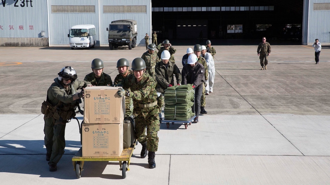 U.S. Marine Corps Maj. Brian D. Psolka, front-left, and members of the Northeastern Army, Japan Ground Self-Defense Force move humanitarian aid and disaster relief supplies aboard an MV-22B Osprey tiltrotor aircraft Nov. 8 during Tomodachi relief exercise 15.2 near Izu Oshima Island, Tokyo Metropolis Prefecture, Japan. TREX 15.2 is an annual, bilateral training exercise that simulates humanitarian assistance and disaster relief missions in Japan while strengthening the U.S. and Japanese alliance. The supplies were being transported to a nearby area where they could be provided to victims of the notional disaster. 