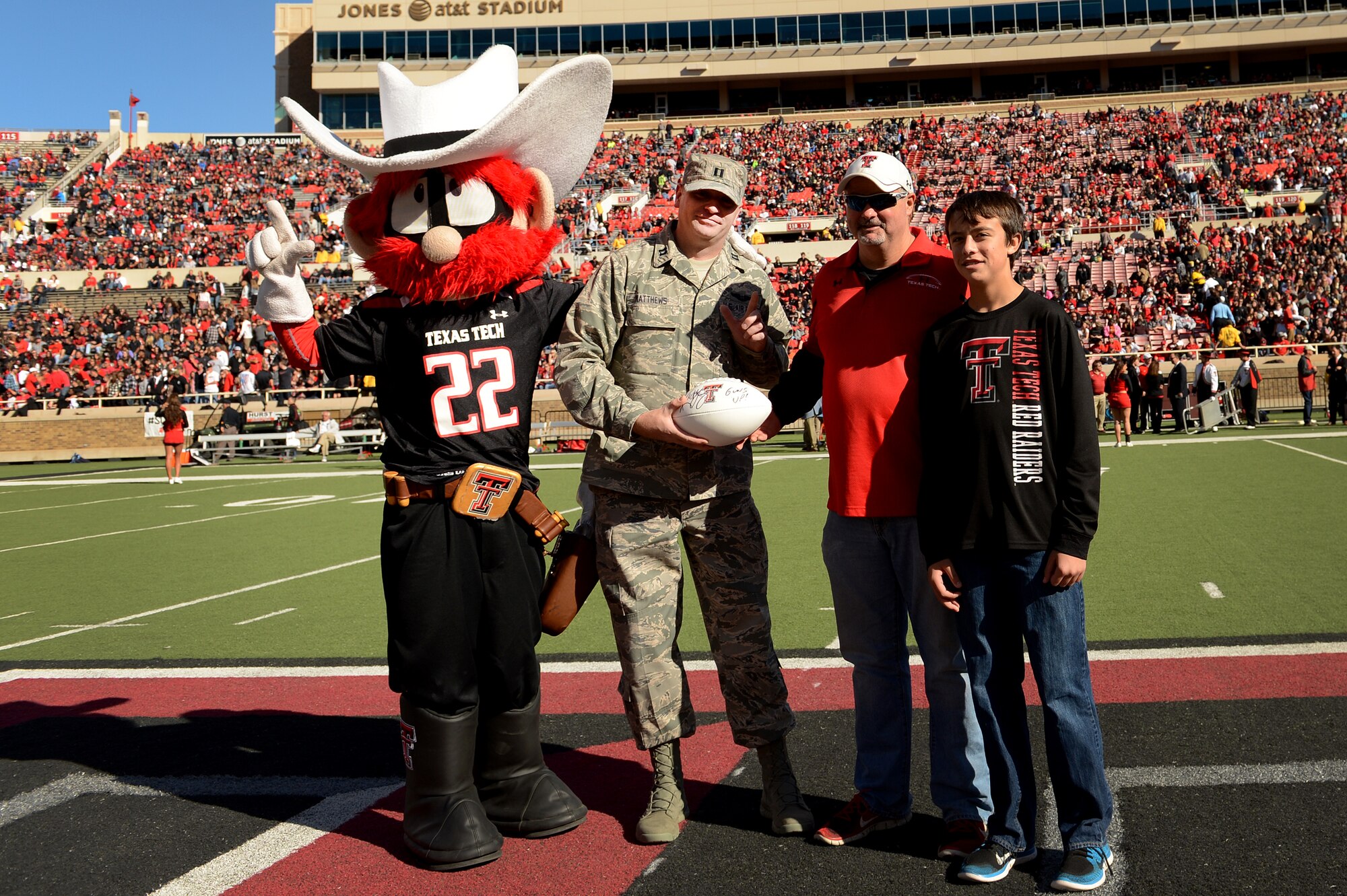 U.S. Air Force Capt. Heath Matthews, 33rd Special Operations Squadron pilot, is presented with a Texas Tech game ball as a thank you for his faithful service to the nation prior to kick-off Nov. 15, 2014 in Lubbock, Texas. Matthews, a graduate of Texas Tech, was selected to be the Cannon representative for the Red Raiders military appreciation game. (U.S. Air Force photo/Staff Sgt. Matthew Plew)