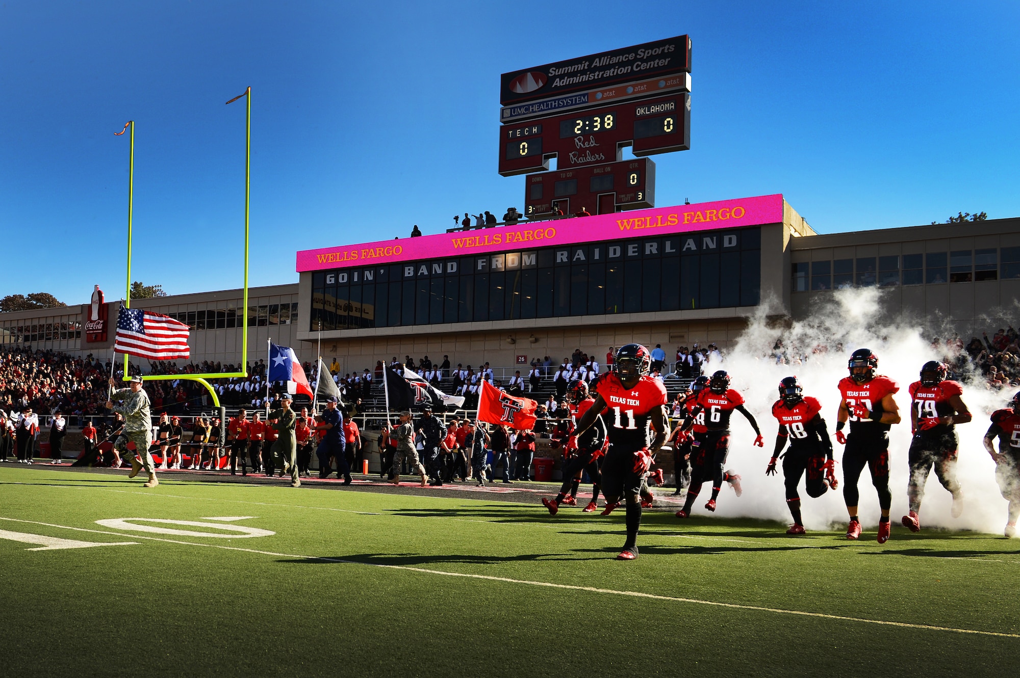 The Texas Tech Red Raiders take the field with U.S. military members displaying the nation’s colors prior to a game Nov. 15, 2014 in Lubbock, Texas. U.S. service members were invited to attend a free football game as the Red Raiders took on the University of Oklahoma Sooners for a military appreciation game. (U.S. Air Force photo/Staff Sgt. Matthew Plew)