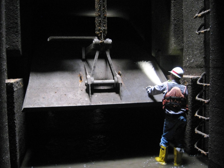 Bob Szemanski, a district maintenance mechanical supervisor, examines a valve inside the dewatered land wall culvert.