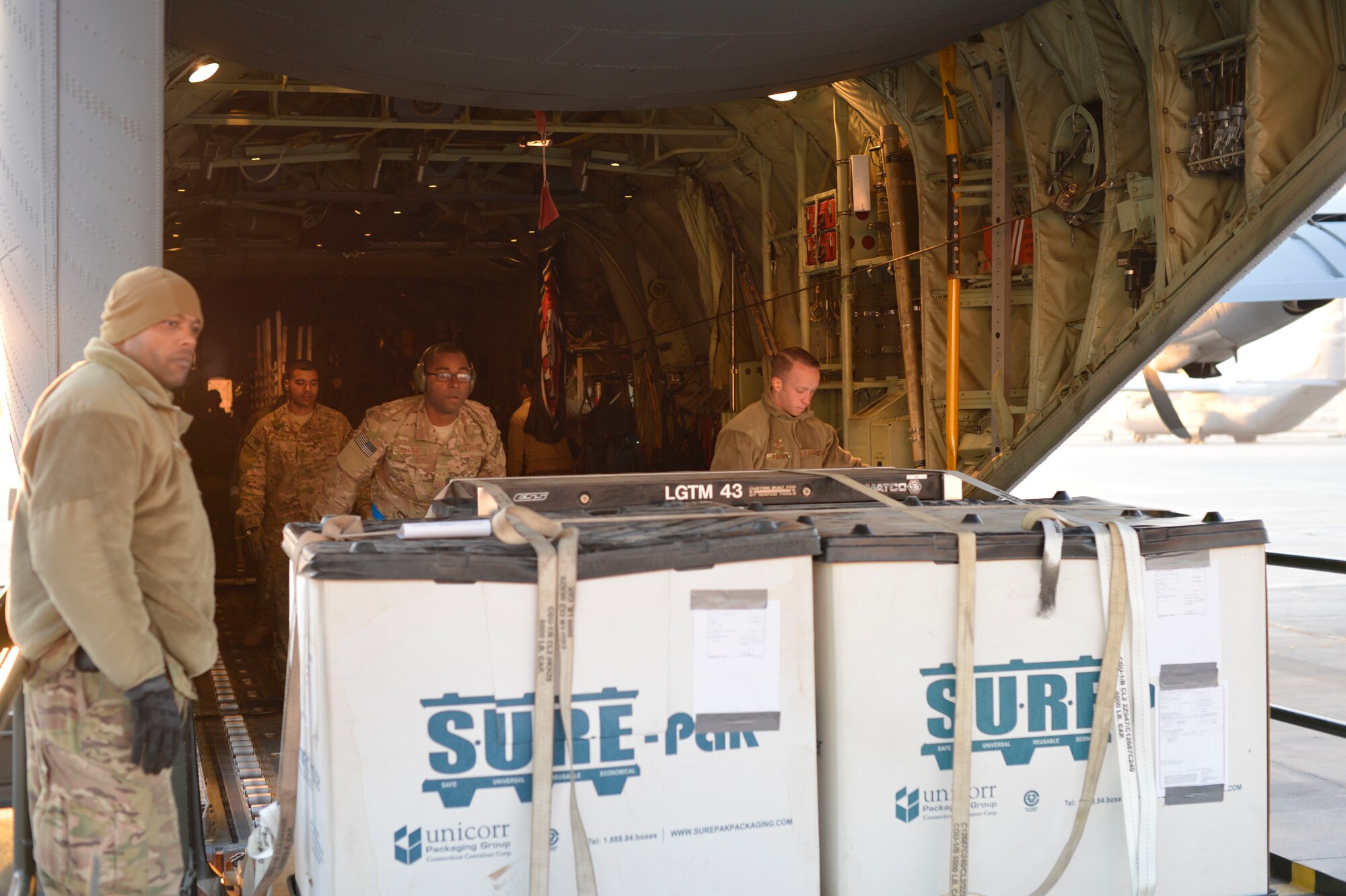 Tech. Sgt. Antwon Pope supervises Senior Airman Devin Teagle and Airman 1st Class Joseph Brown, all from 455th Expeditionary Aerial Port Squadron, as they unload cargo off a C-130 Hercules on Bagram Air Field, Afghanistan, Nov. 9, 2014. The cargo arrived from forward operating base Shindand, Afghanistan, on a C-130 Hercules. Over the last three weeks the 455th EAPS completed the load and unload of 73 aircraft. (U.S. Air Force photo by Staff Sgt. Jennifer M. Stai/released)