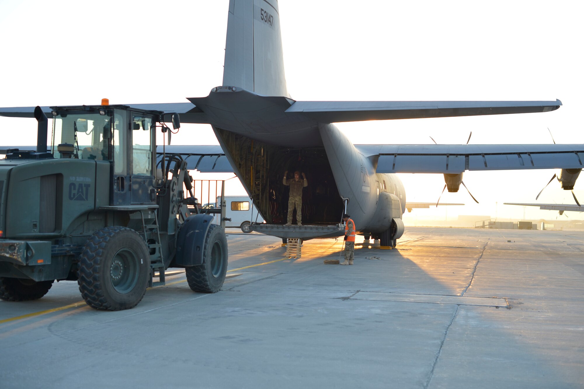 Airmen from the 455th Expeditionary Aerial Port Squadron prepare to unload cargo from a C-130 Hercules on Bagram Air Field, Afghanistan, Nov. 9, 2014. The cargo arrived from Forward Operating Base Shindand, Afghanistan. During the Shindand operation, a team of 11 aerial port Airmen and two vehicle maintainers from 455th Air Expeditionary Wing prepared, inspected and loaded all equipment and vehicles departing Shindand by air. (U.S. Air Force photo by Staff Sgt. Jennifer M. Stai/released)