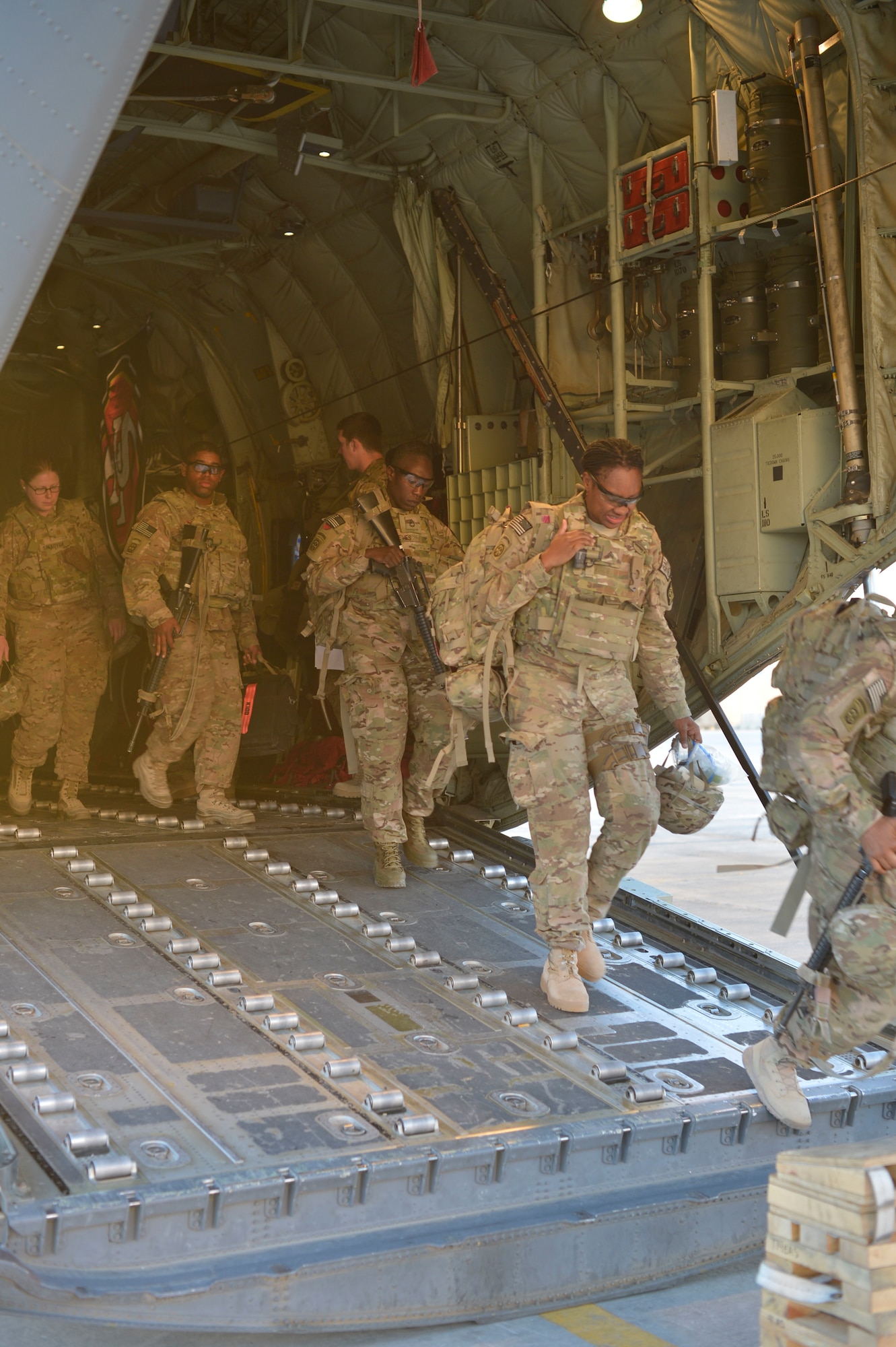 Soldiers arrived from Shindand, Afghanistan, depart a C-130 Hercules at Bagram Air Field, Afghanistan, Nov. 9, 2014. In the last two months, the 455th Air Expeditionary Wing pushed 2,200 passengers and 4,300 short tons of cargo out of Shindand, Afghanistan. (U.S. Air Force photo by SSgt Jennifer M. Stai/released)