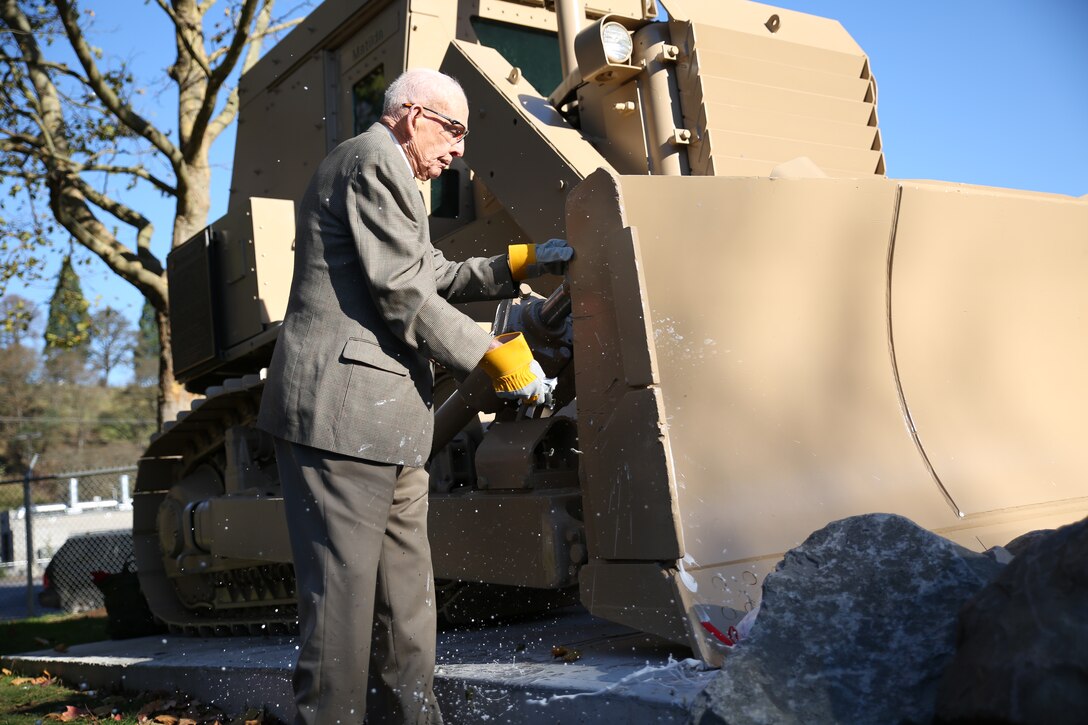Retired Col. James “Rip” Harper christens a D7G bulldozer used in Operations Desert Shield, Desert Storm and Iraqi Freedom, outside the Naval Support Activity Portland after 6th Engineer Support Battalion’s battle color rededication ceremony in Portland, Ore., Nov. 15, 2014.The battalion celebrated the 70th anniversary of its formation with a rededication ceremony and paid homage to Harper, the battalion’s first adjutant. Harper served as the unit’s first adjutant as a first lieutenant in 1944, when the unit was formed in Guadalcanal during World War II. (U.S. Marine Corps photo by Cpl. Tiffany Edwards)